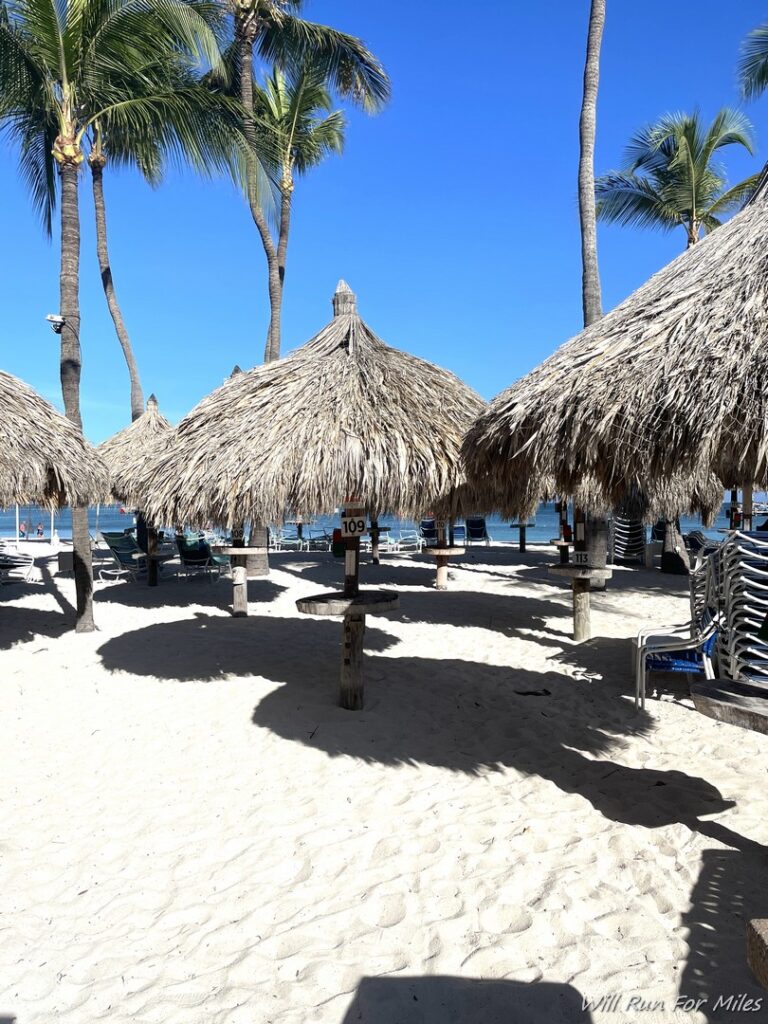 a group of straw umbrellas on a beach