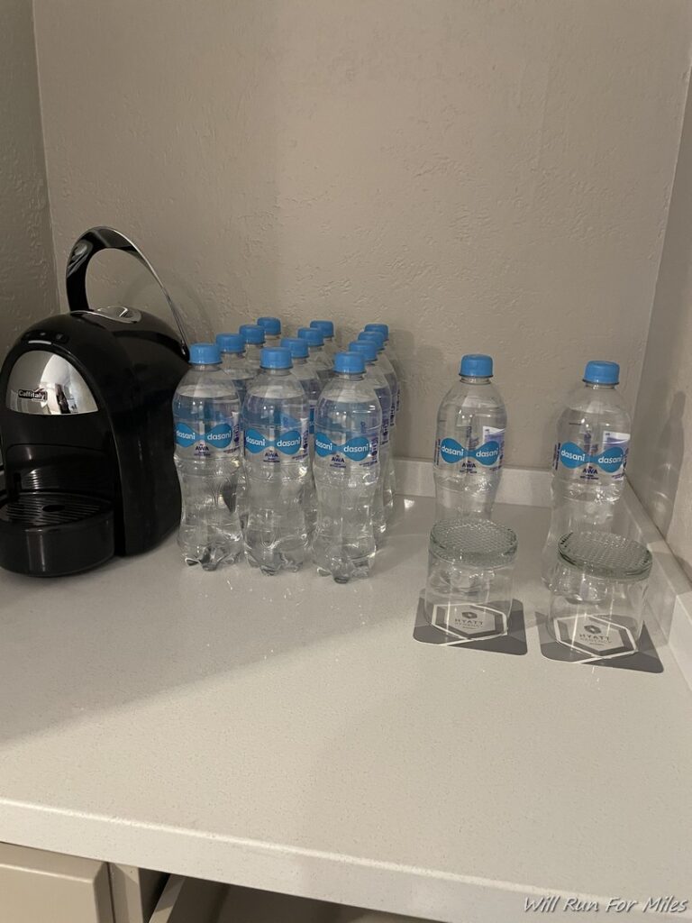 a group of water bottles and cups on a counter
