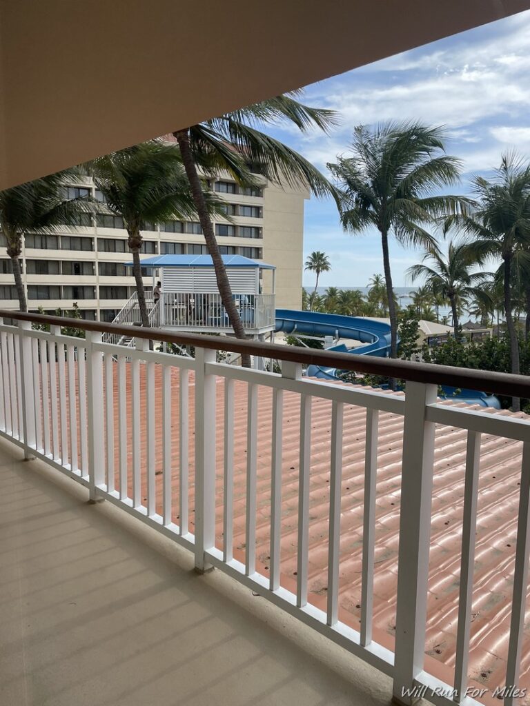 a balcony with a slide and palm trees