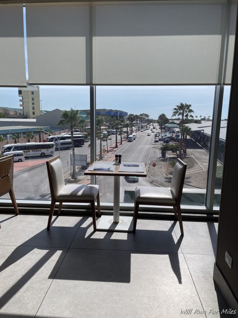 a table and chairs in a room with a view of the street and cars