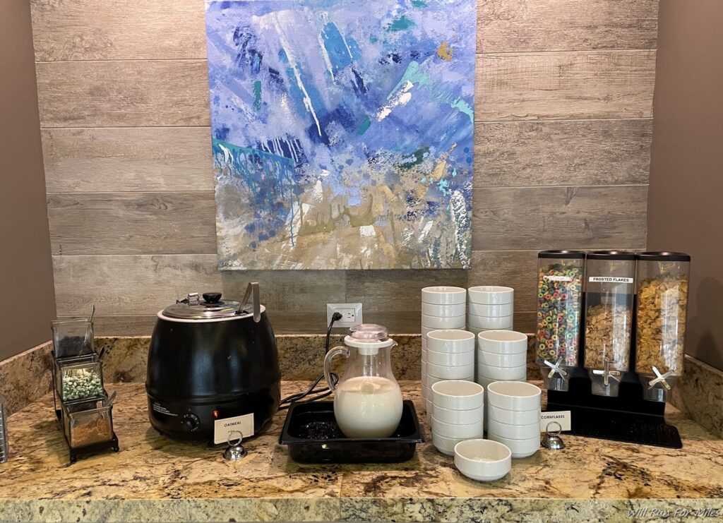 a coffee maker and white cups on a counter