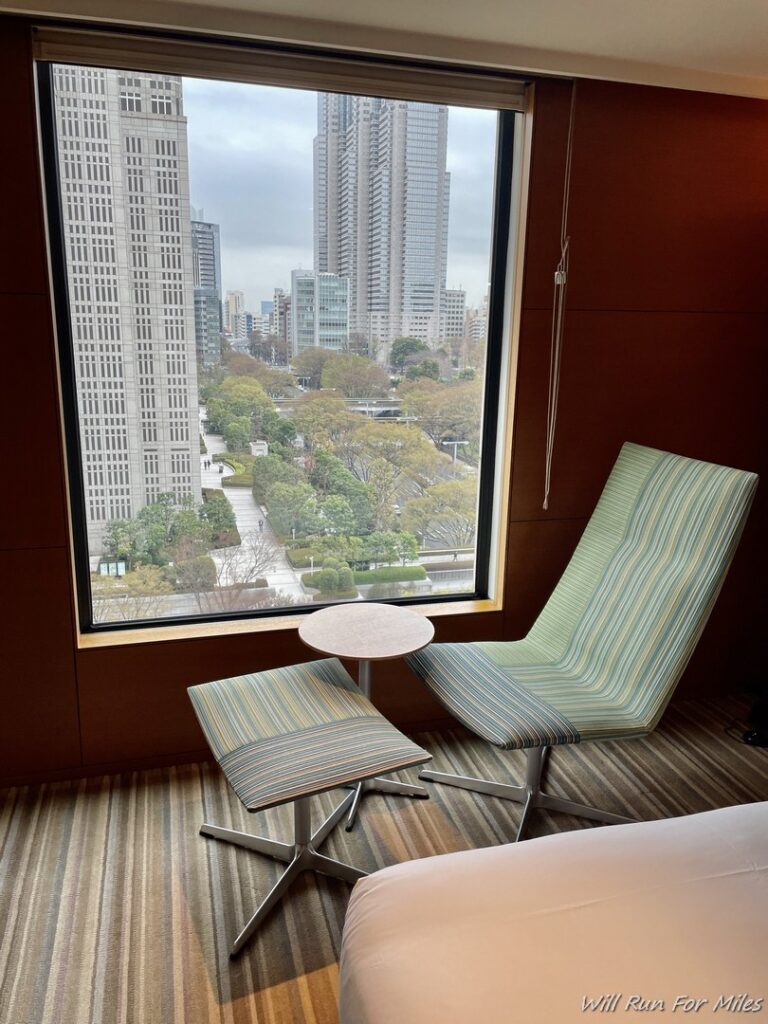 a chair and table in a room with a view of a city