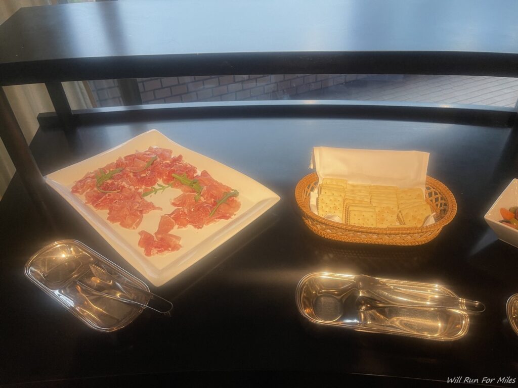 a plate of meat and crackers on a table