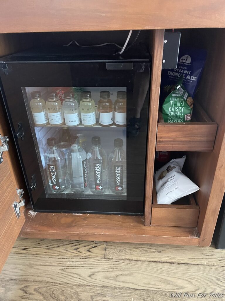 a cabinet with bottles and a bag of food