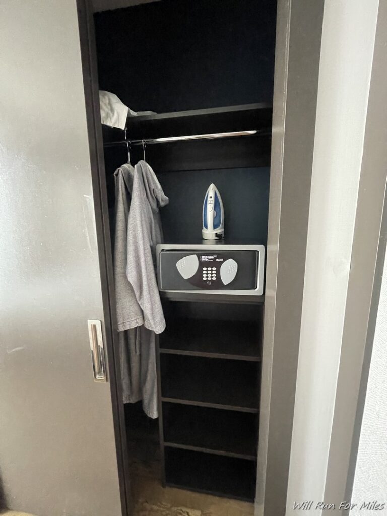 a closet with a iron and a ironing board