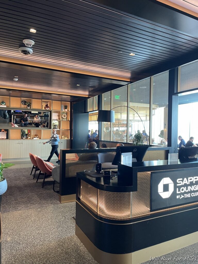 a lobby with a black counter and a person walking