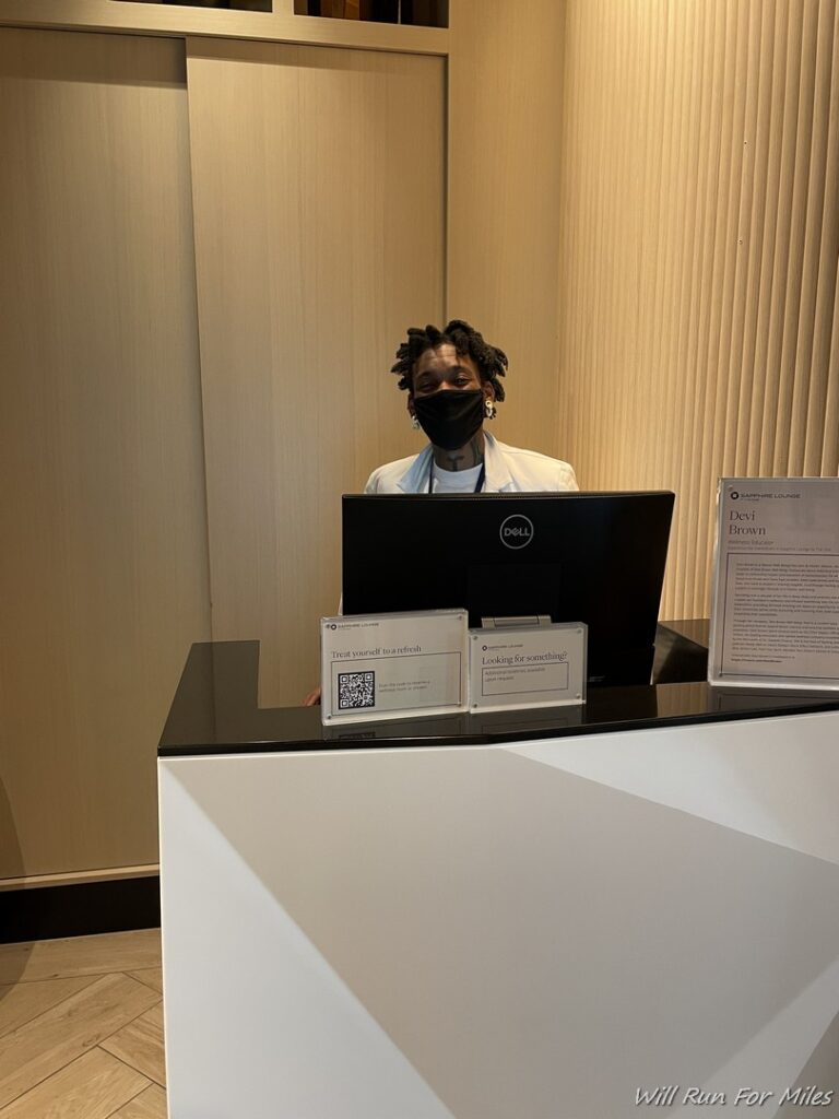 a person wearing a face mask behind a computer