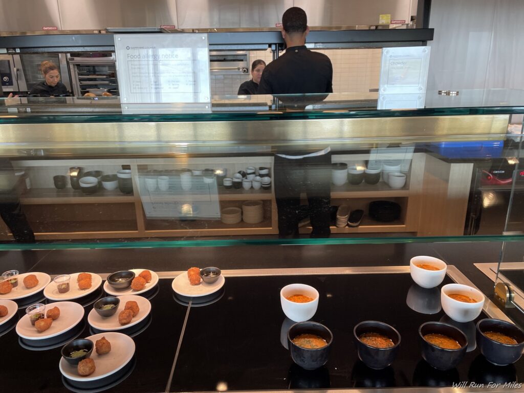a man behind a counter with food on plates