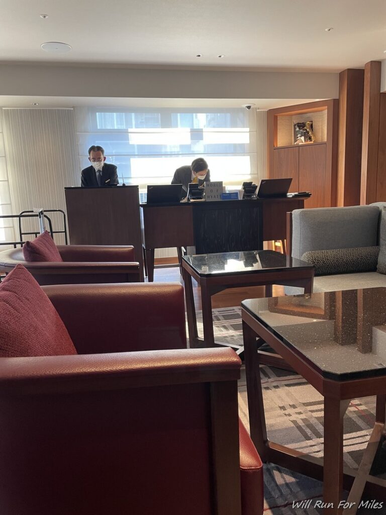 a man in a mask behind a desk in a hotel