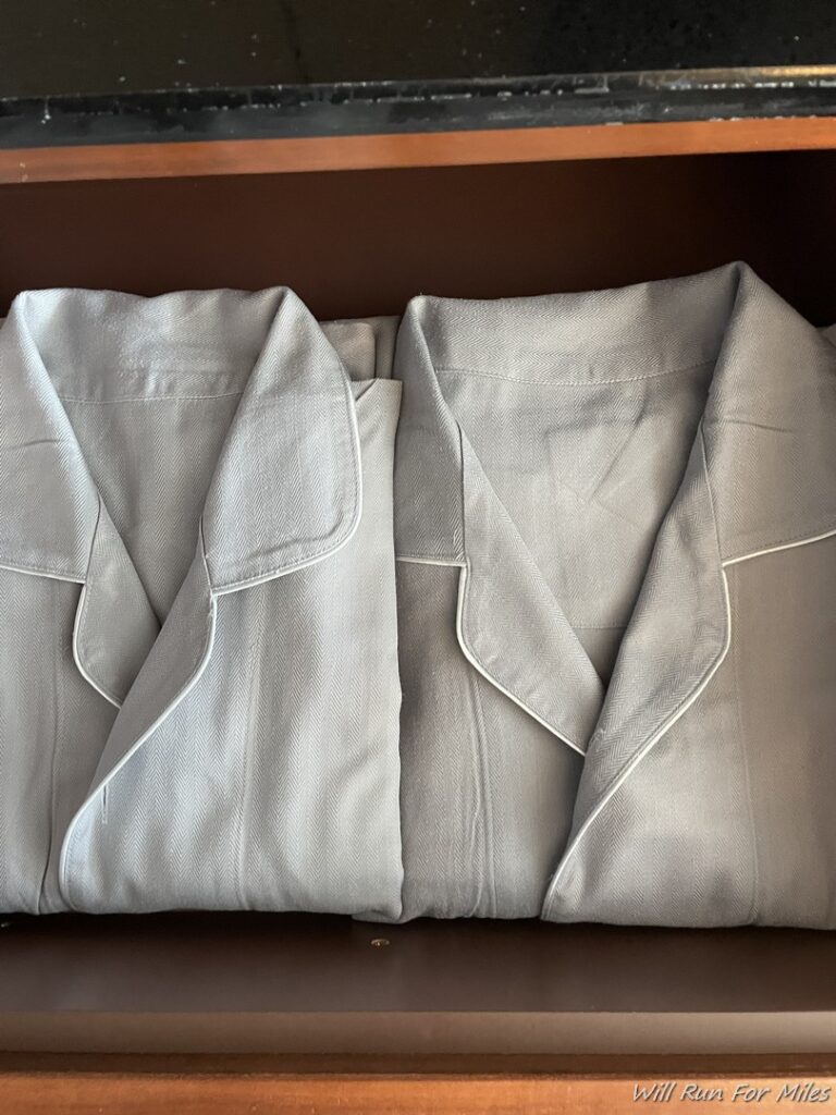 a folded grey pajamas on a shelf