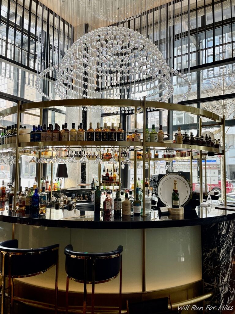 a bar with a chandelier and bottles