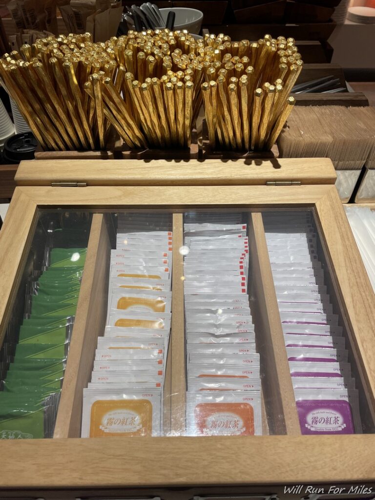 a wooden box with a glass top and a group of gold straws in the front