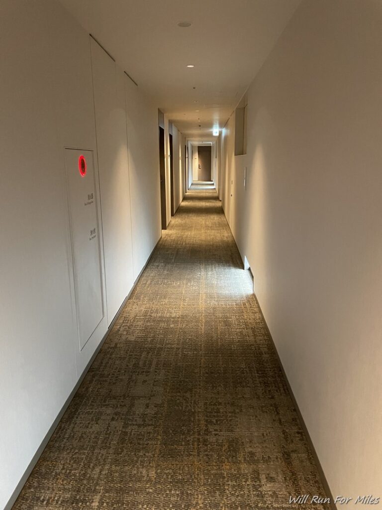 a long hallway with white walls and a carpeted floor