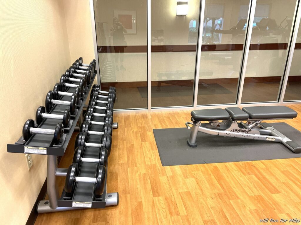 a gym with weights and a rack of weights