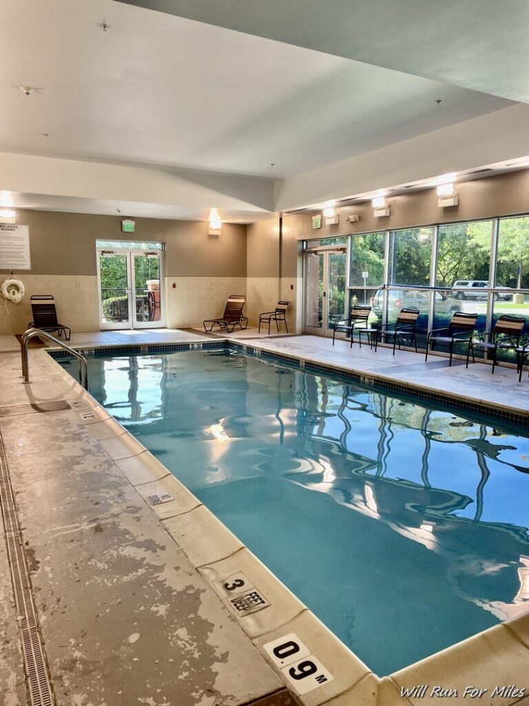 a indoor pool with chairs and a door