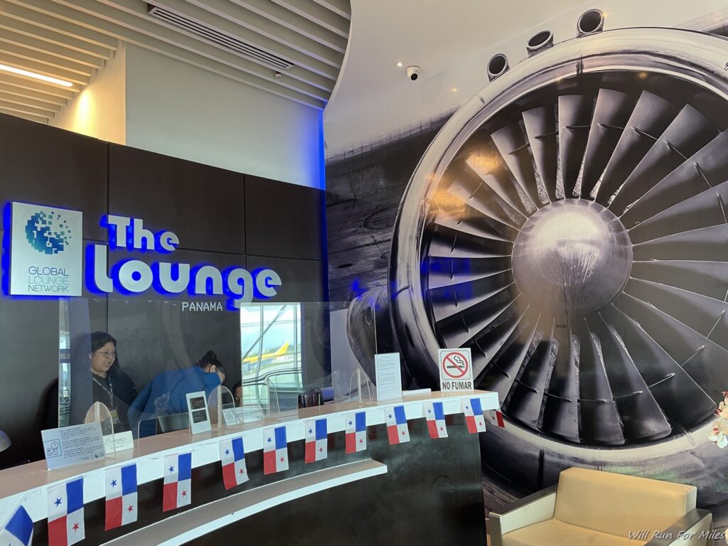 a lounge with a large fan and a sign