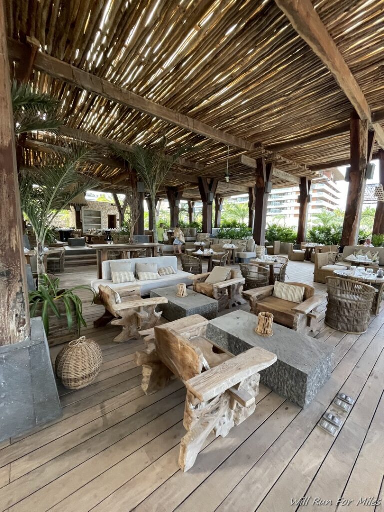 a patio with a wooden structure and tables and chairs