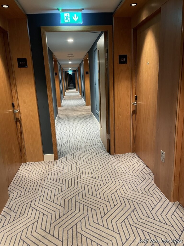 a hallway with wooden doors and carpet