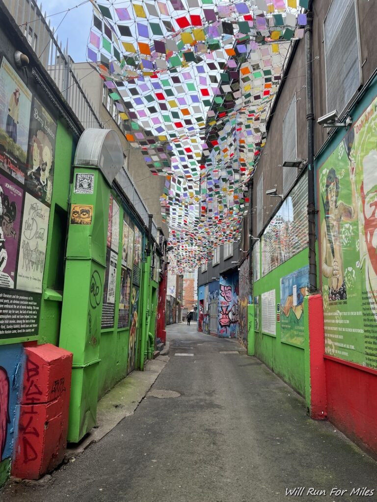 a colorful flags over a narrow alleyway
