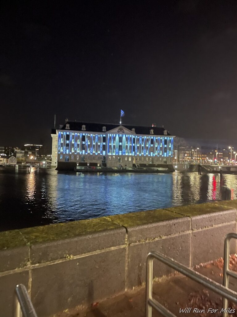 a building with blue lights on the side of the water