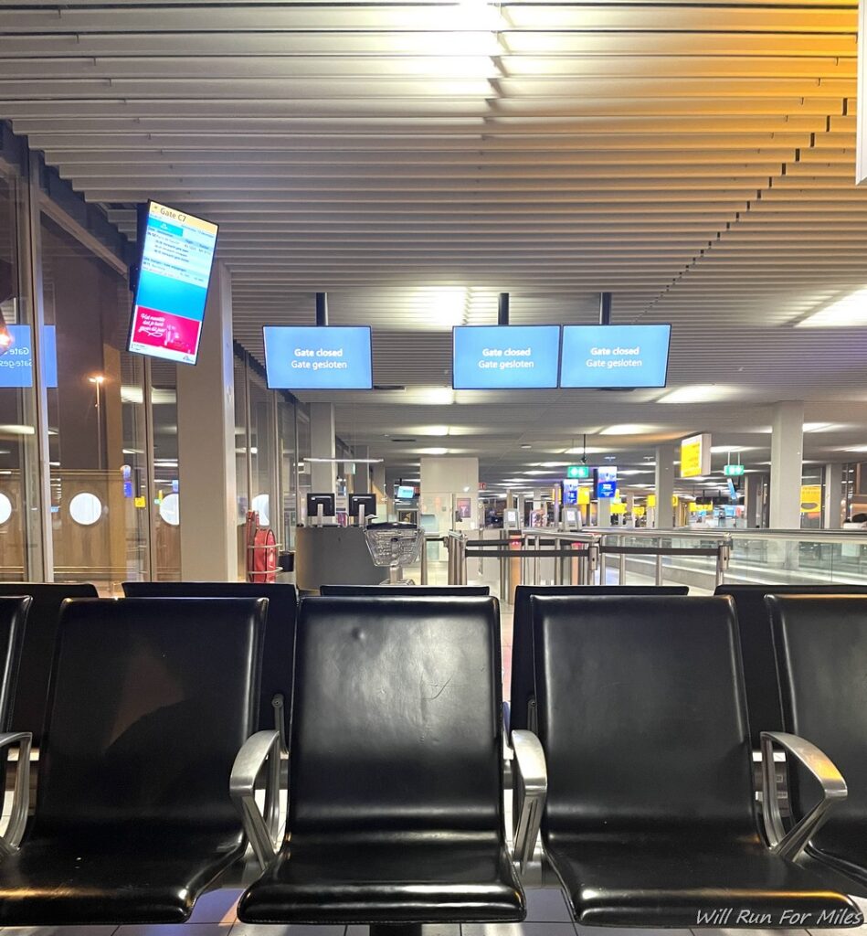 a row of black chairs in an airport