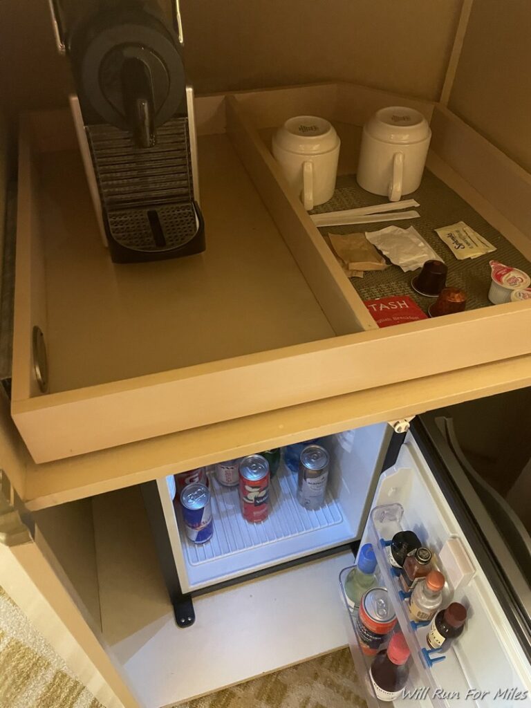 a small refrigerator with a coffee machine and a small fridge