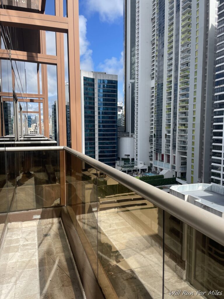 a balcony with glass railings and a city skyline