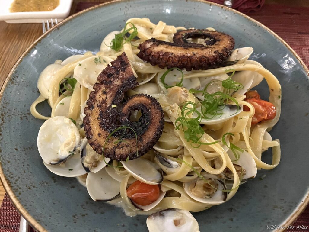 a plate of pasta with octopus and clams