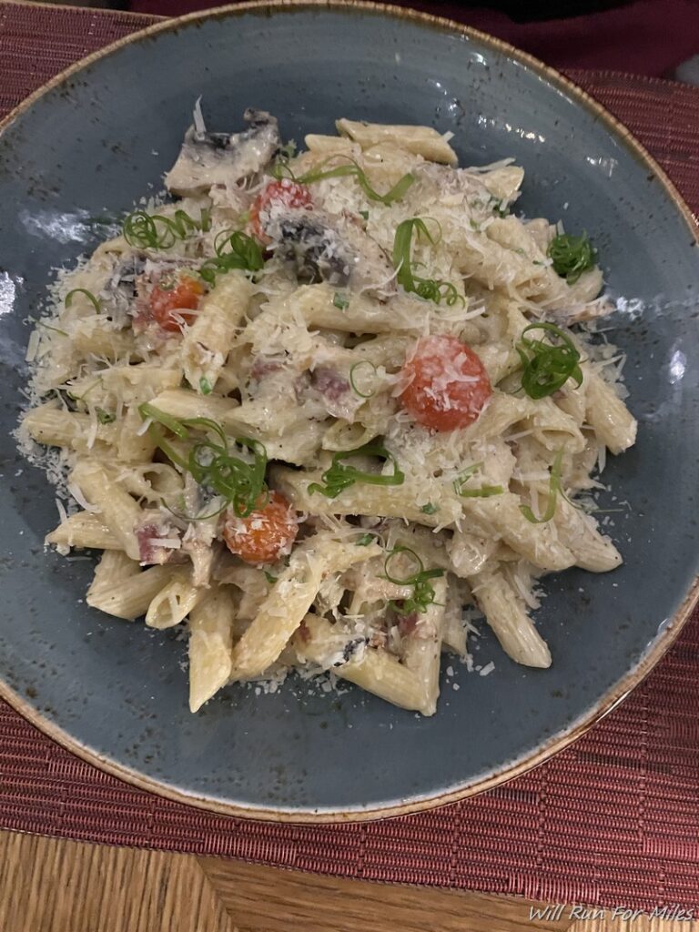 a plate of pasta with cheese and vegetables