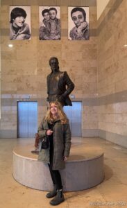 a woman standing next to a statue