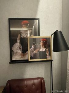 a framed picture of a woman and a glass of wine