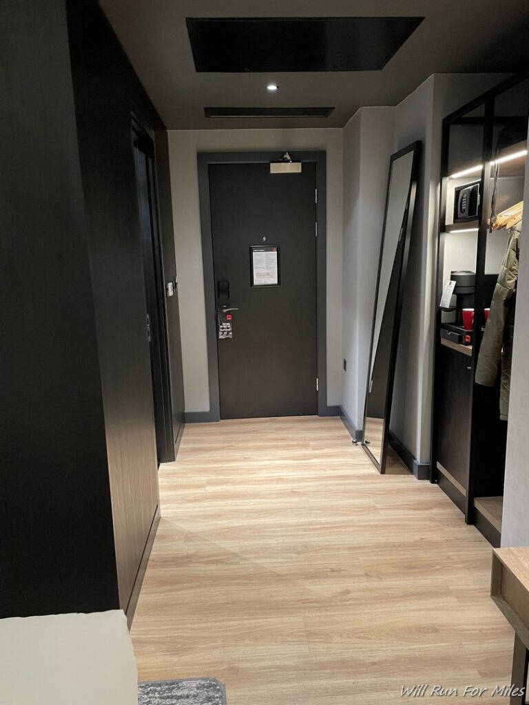 a hallway with a door and mirror