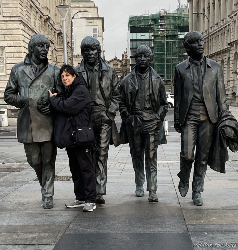 a woman posing with statues of people