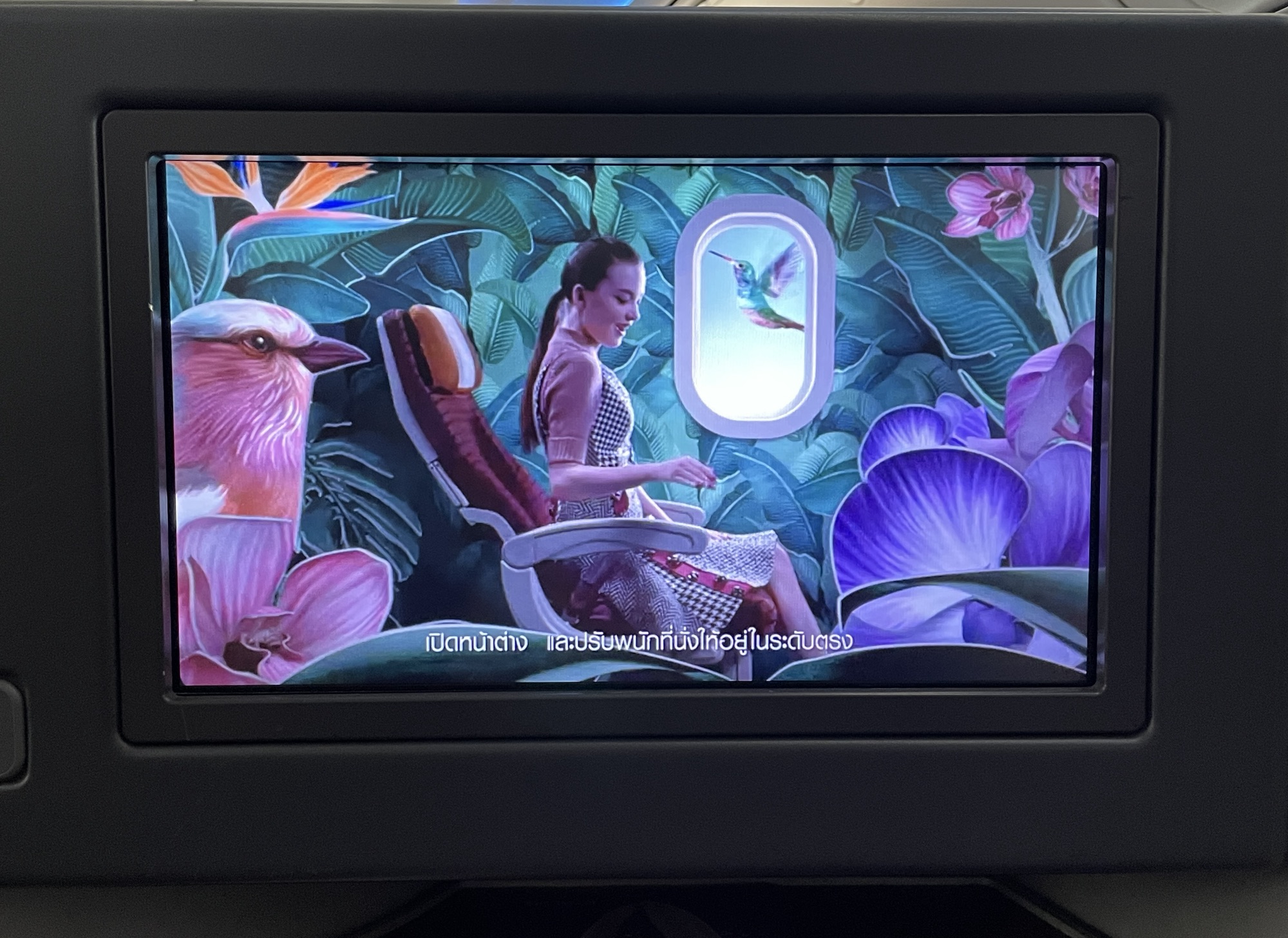 a screen with a woman sitting in a chair and birds flying out of the window