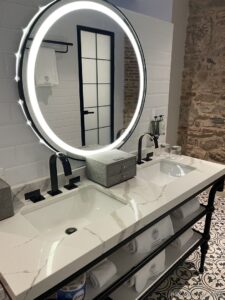 a bathroom with a round mirror