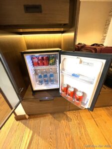 a mini fridge with cans of soda and cans of water inside