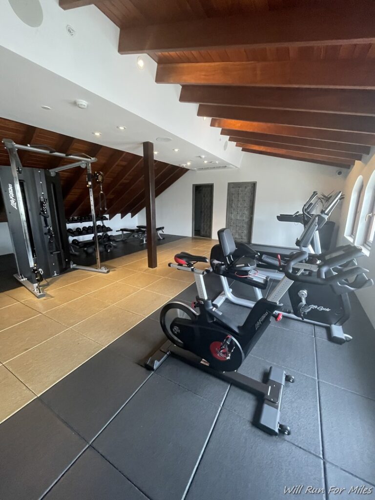 a room with exercise bikes and a wood ceiling