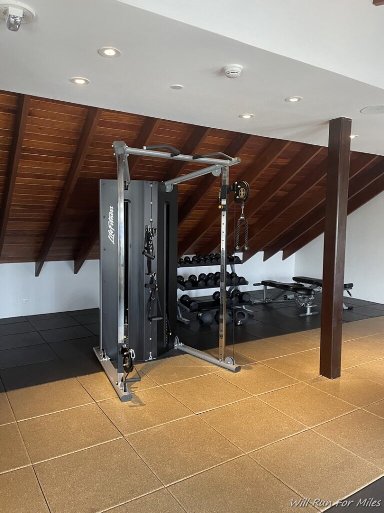 a gym with a machine and weights in the ceiling