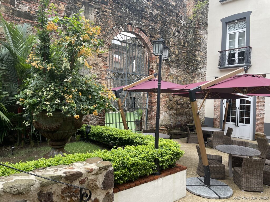 a patio area with chairs and tables and a stone wall