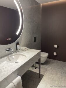 a bathroom with a round mirror and a sink