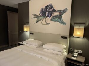 a bed with pillows and a painting on the wall