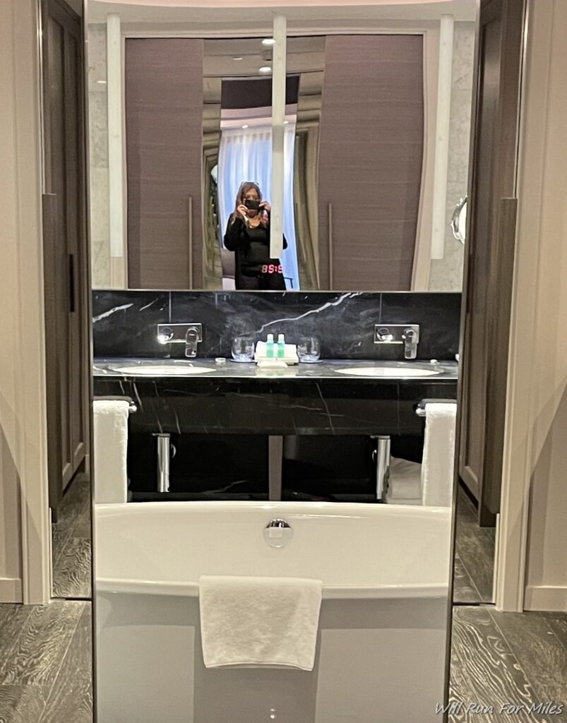 a mirror of a bathroom with a sink and a bathtub