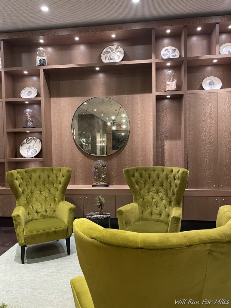 a room with a green chair and a round mirror