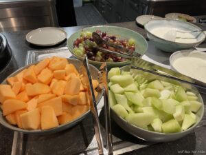 a group of bowls of fruit and a bowl of grapes