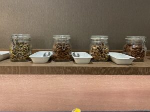 a group of jars with nuts and bowls on a shelf
