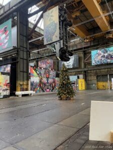 a large room with art paintings and a tree