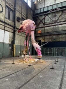 a large pink flamingo statue in a warehouse