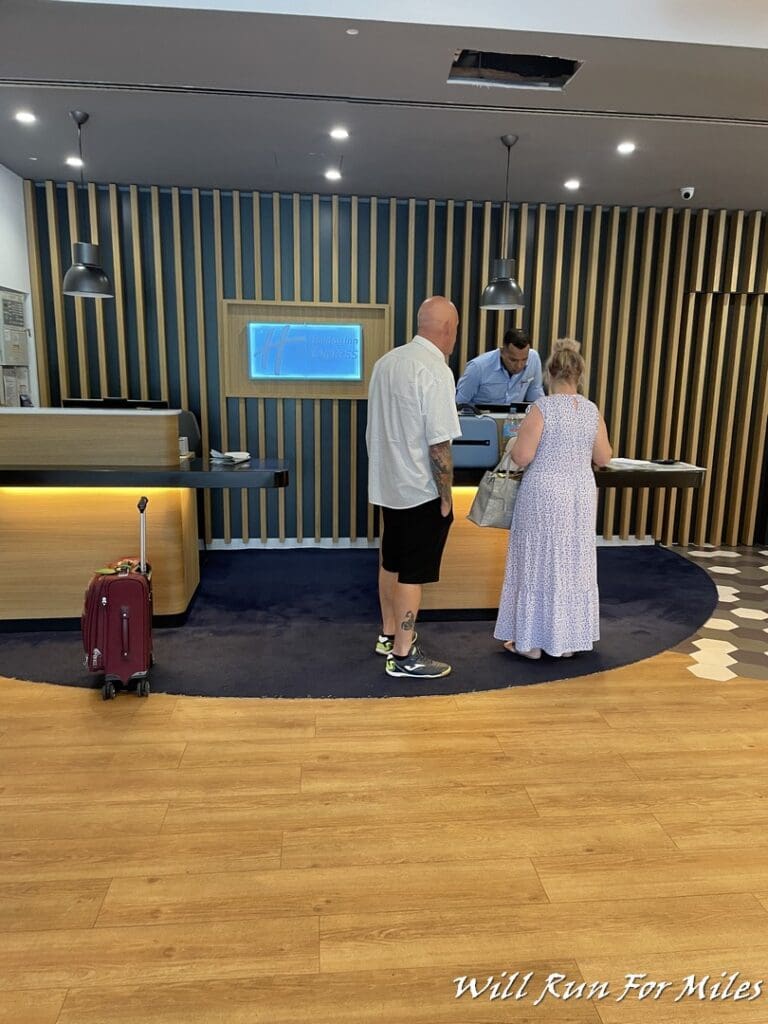 a man and woman standing in front of a hotel reception