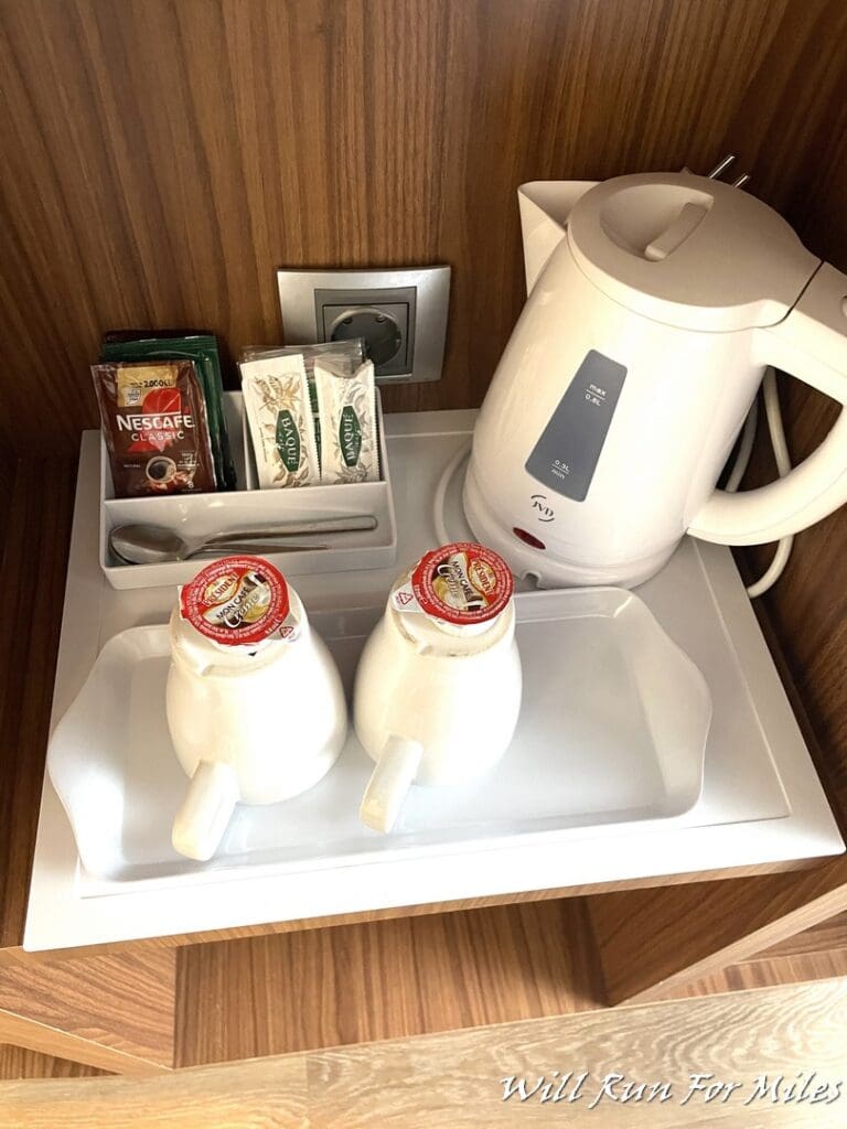 a tray with two white cups and a teapot on it