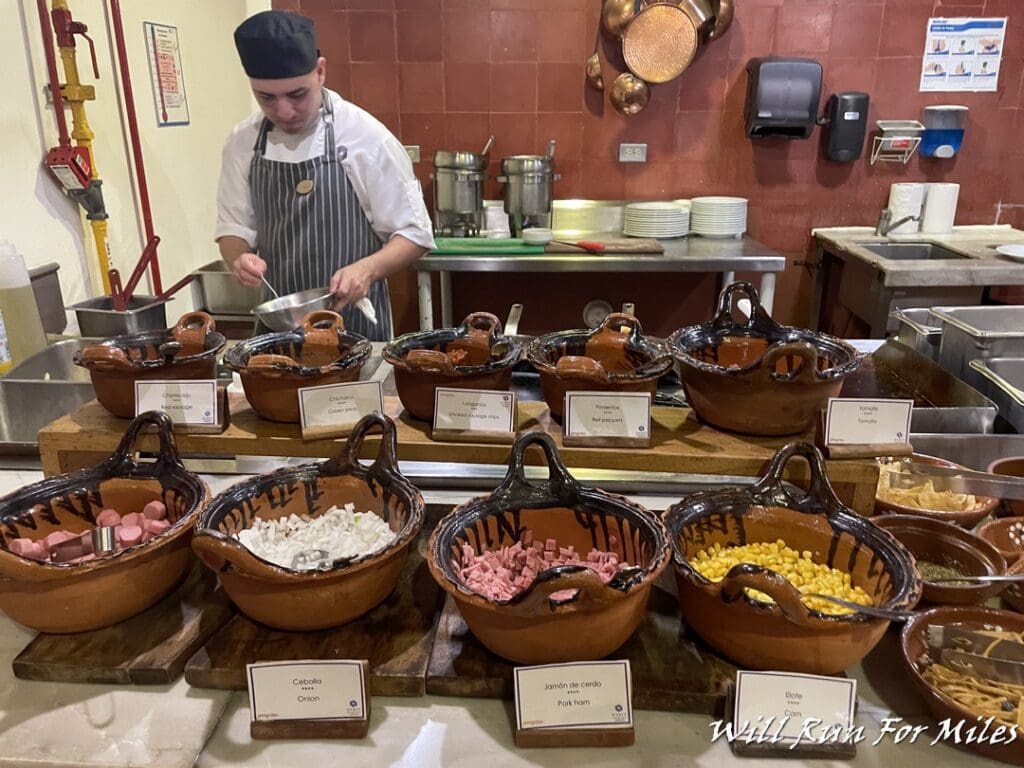 a man in a kitchen with many bowls of food